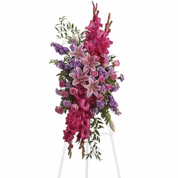 Tall floral spray with pink lilies, roses, and purple flowers on a stand
