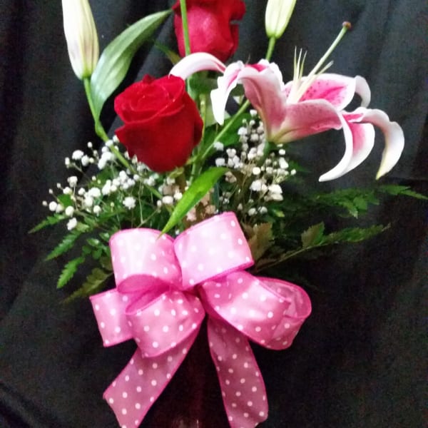 Bouquet of red roses and pink lilies with a pink bow