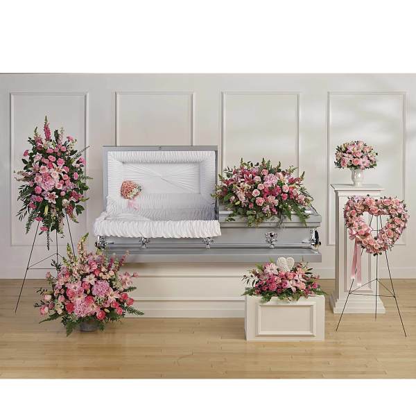 Pink floral funeral casket spray with matching standing arrangements
