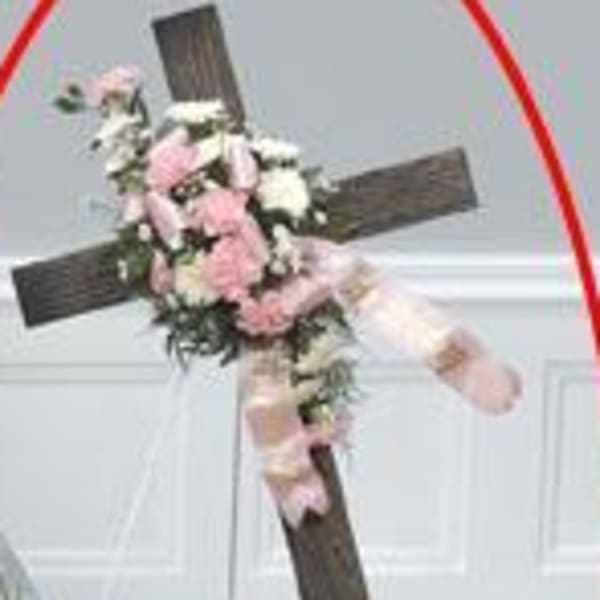 Floral cross with pink and white flowers on a stand