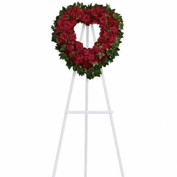 Heart-shaped red rose wreath on a white standing easel