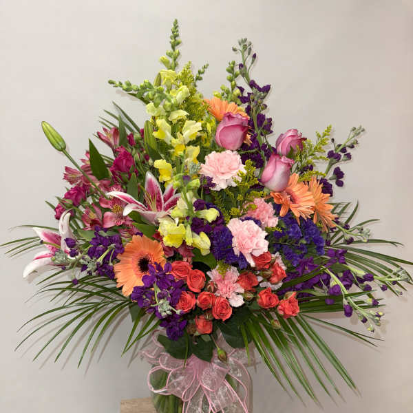 Mixed bouquet in a glass vase with pink, purple, orange, and yellow flowers