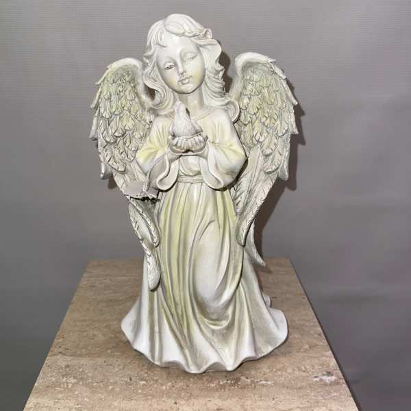 White angel figurine holding a small bird
