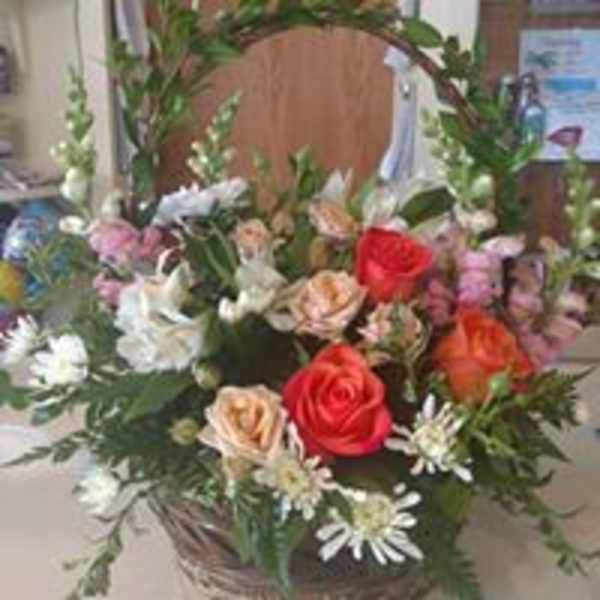 Mixed bouquet of roses and white daisies in a basket