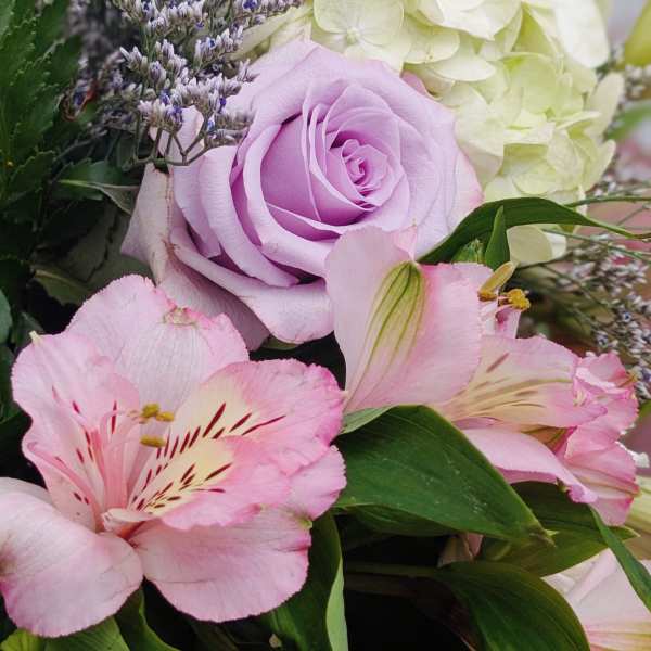 Bouquet of pink lilies, lavender rose, and white hydrangea