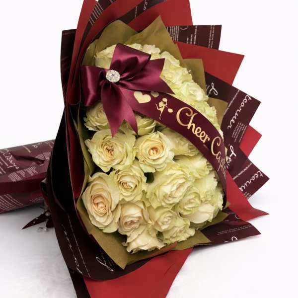 Bouquet of cream roses wrapped in burgundy and red paper with a satin bow