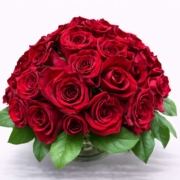 Round bouquet of red roses in a glass vase