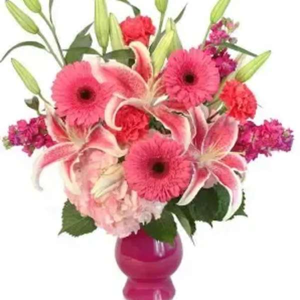 Pink lilies and gerbera daisies in a magenta vase