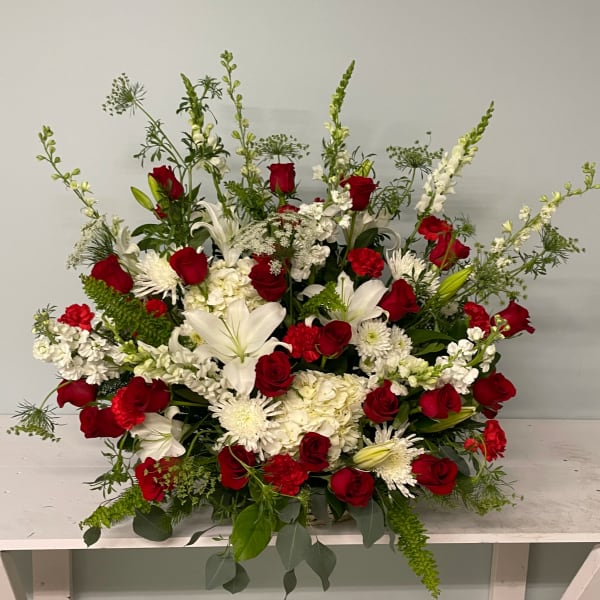 Large red and white floral arrangement with roses and lilies