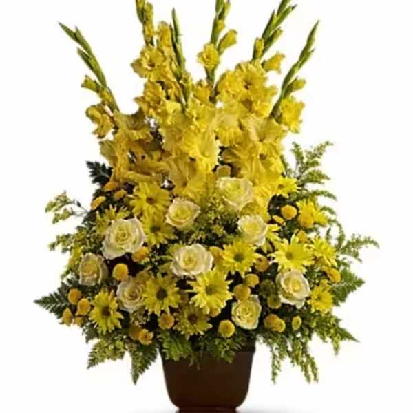 Tall yellow floral arrangement in a brown urn vase