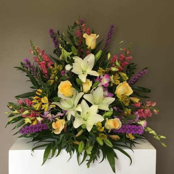 Large mixed bouquet with white lilies, yellow roses, and purple accents