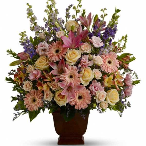 Mixed pink and cream flowers in a brown urn vase