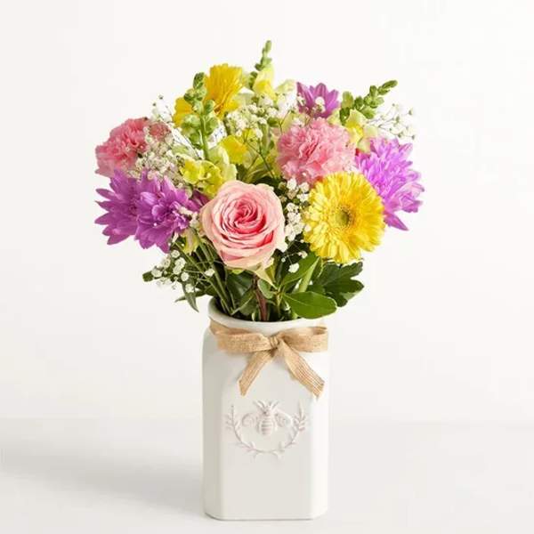 Mixed bouquet in a white vase with a burlap bow