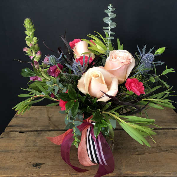Bouquet of peach roses and pink flowers in a glass vase