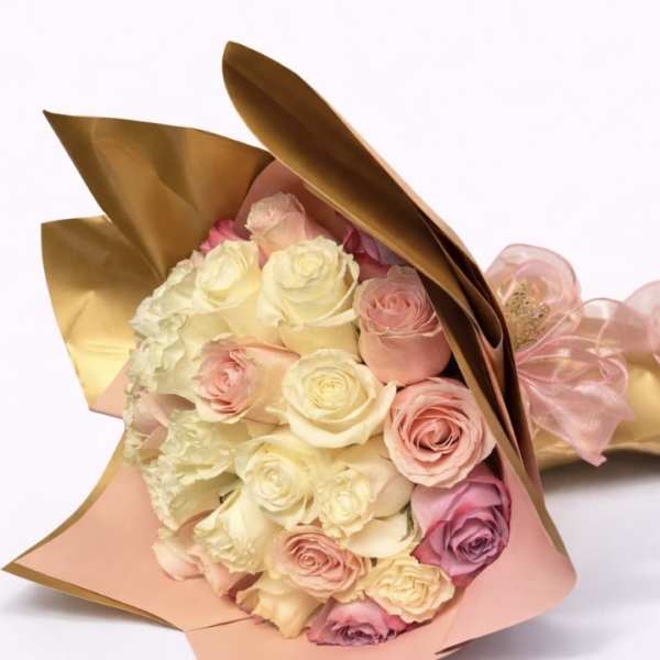Bouquet of pink and cream roses wrapped in gold and blush paper