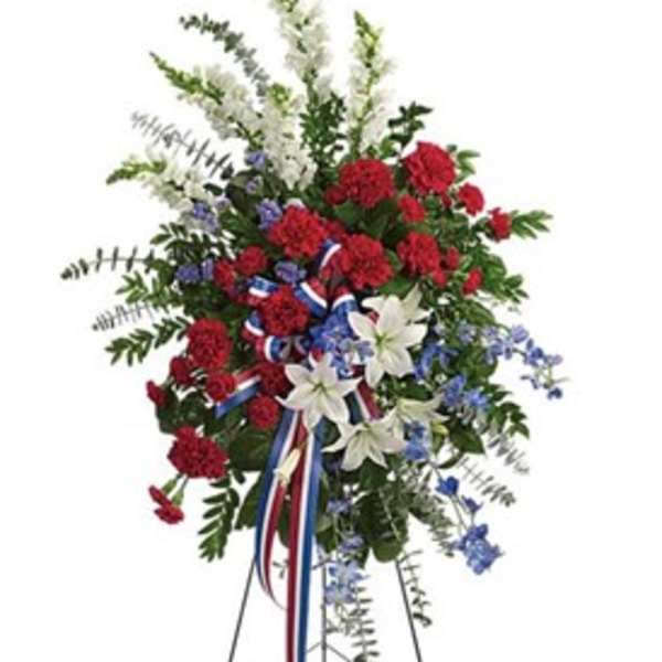 Standing floral spray with red, white, and blue flowers on an easel