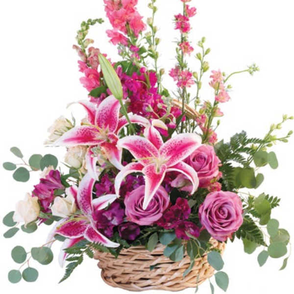 Basket arrangement of pink stargazer lilies, purple roses, and other pink flowers.