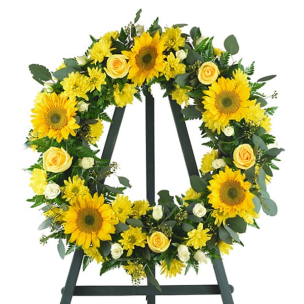 Yellow sunflower and rose wreath on a black easel