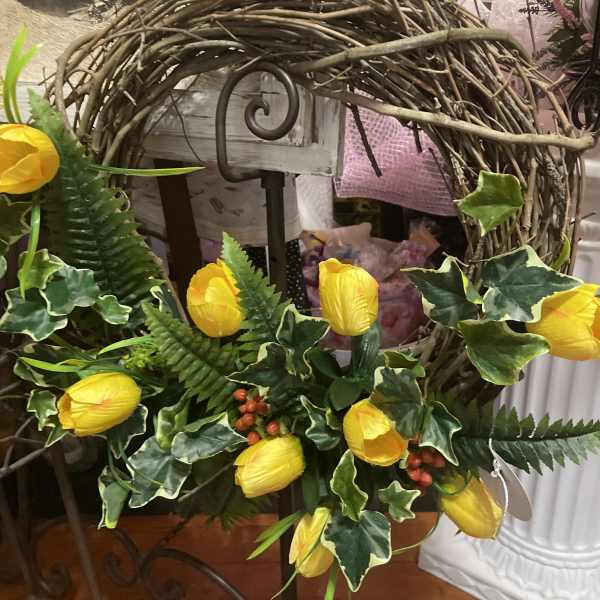 Yellow tulips arranged with ivy in a twig wreath