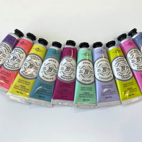 A row of colorful hand cream tubes arranged on a white surface