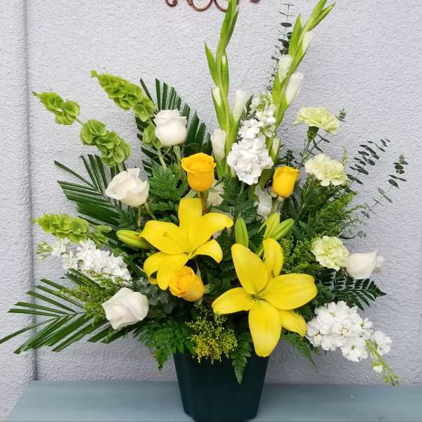 Yellow lilies and white roses in a dark vase