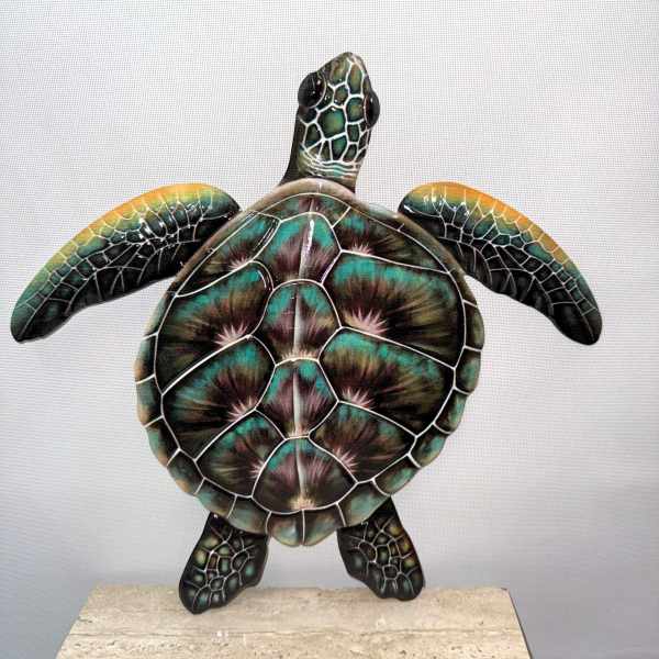 Decorative turtle sculpture with iridescent shell on a stone base