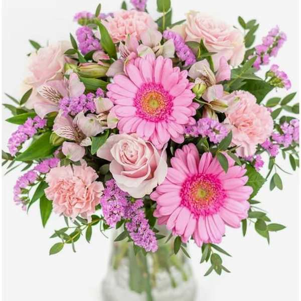 Pink gerbera daisies and roses in a glass vase