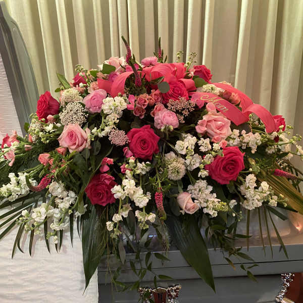 Large pink and white floral casket spray with roses and stock