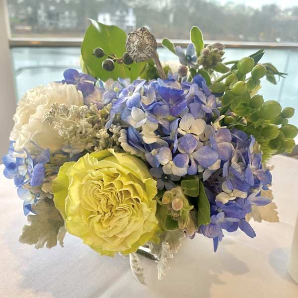 Bouquet of blue hydrangea, yellow rose, and white blooms