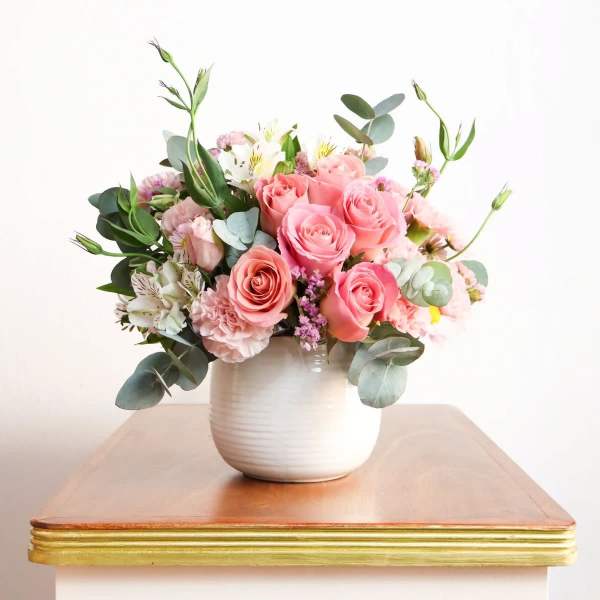 Pink rose bouquet in a white ceramic vase