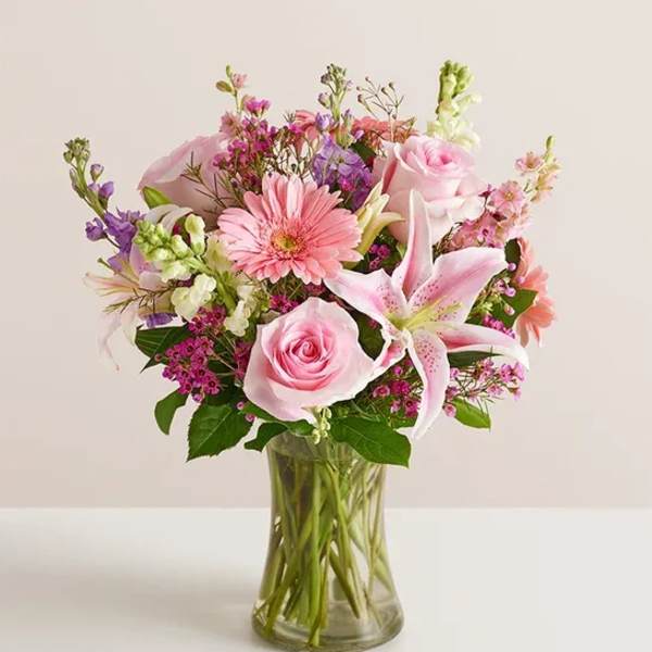 Pink roses and lilies in a clear glass vase
