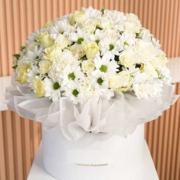 White roses and daisies arranged in a white hatbox