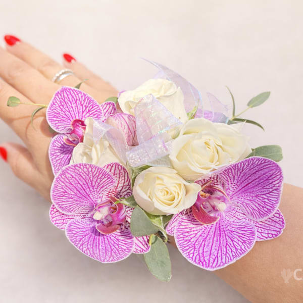 Pink orchid corsage with white roses worn on a wrist