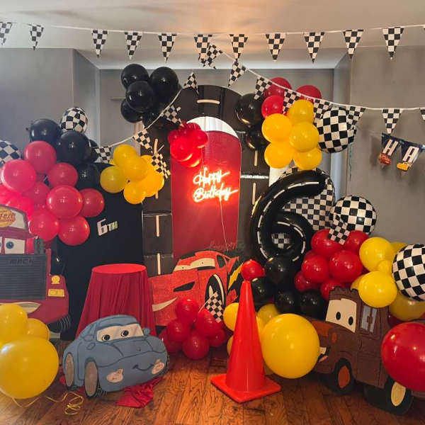 Cars-themed birthday party setup with balloons and character cutouts