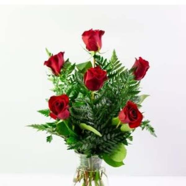 Red roses arranged in a clear glass vase