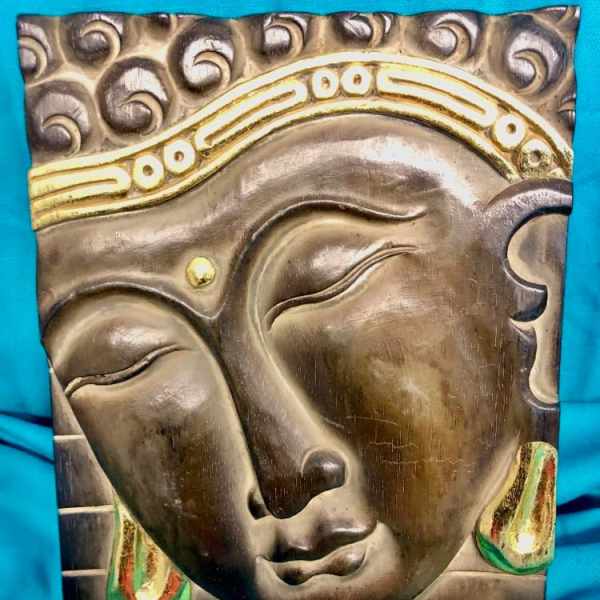 Decorative wall art with a Buddha face on a blue background