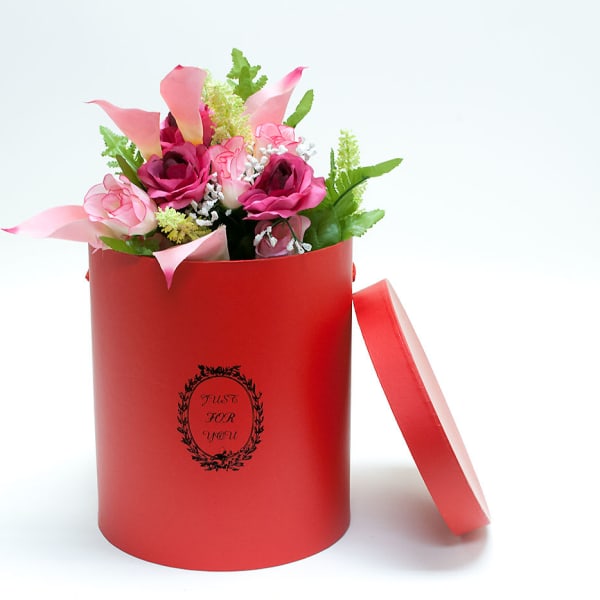 Pink and magenta flowers in a red gift box with a lid