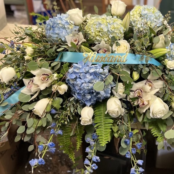 Large blue and white floral arrangement with a blue ribbon