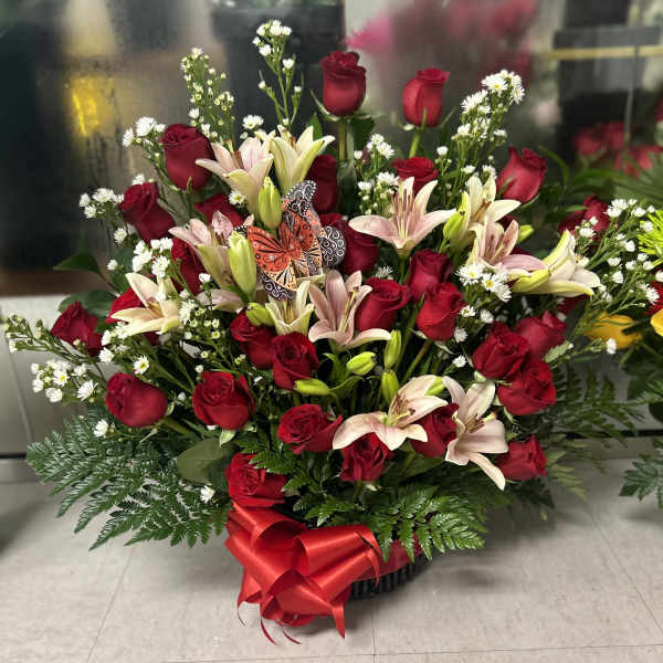 Large bouquet of red roses and pale lilies with a red ribbon