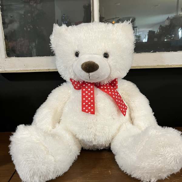 White teddy bear with a red polka-dot ribbon