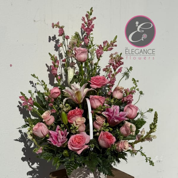Pink roses and lilies arranged in a white basket