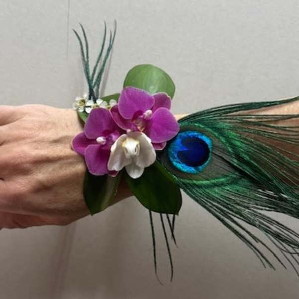 Wrist corsage with purple orchids and peacock feathers
