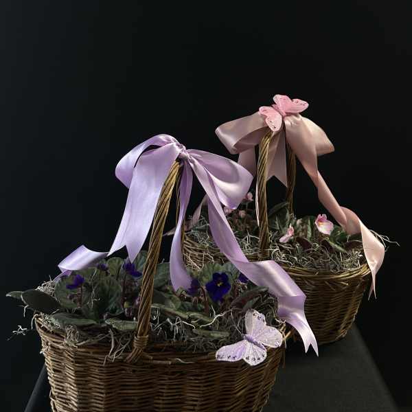 Two wicker baskets with small purple flowers and pastel ribbons