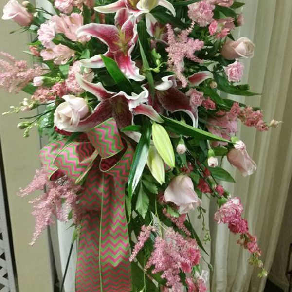 Tall pink and white floral spray with lilies and roses on a stand