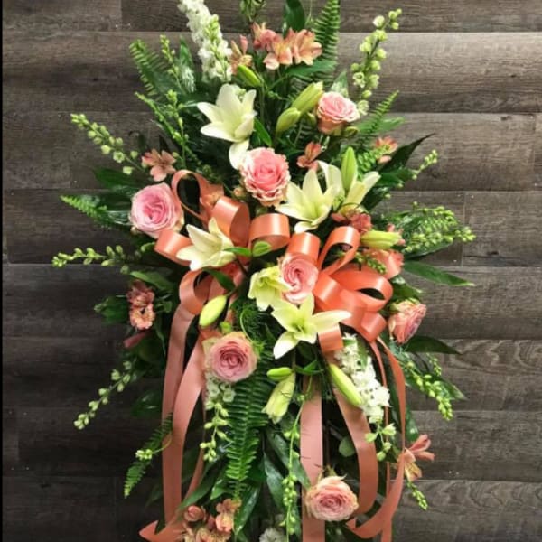 Tall floral standing spray with pink roses, white lilies, and peach ribbon