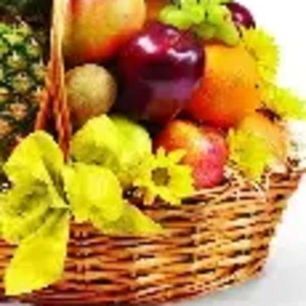 Fruit basket with apples, grapes, and yellow flowers in a wicker basket