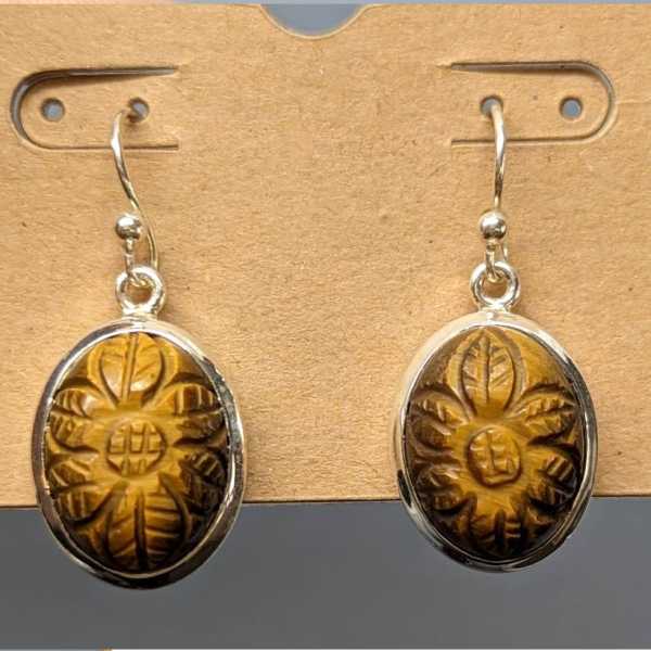 Pair of oval dangling earrings with carved amber-colored stones