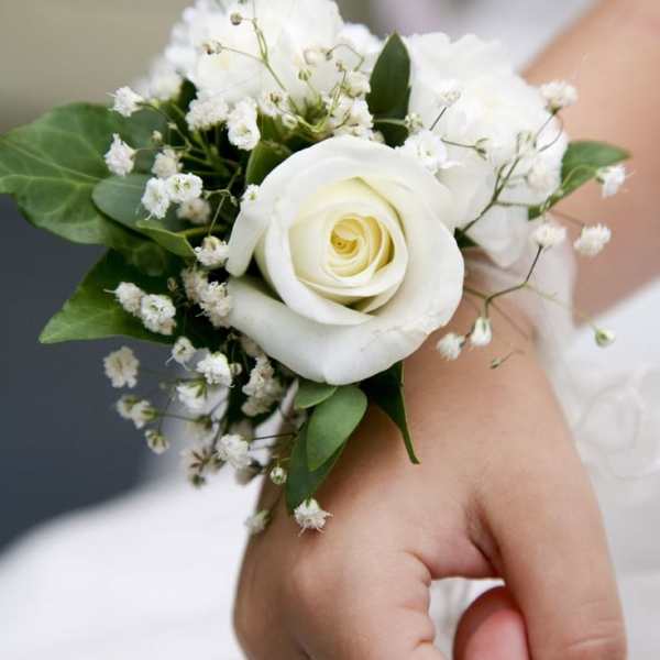 White rose wrist corsage with baby's breath and greenery