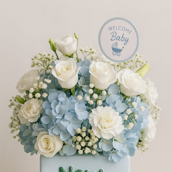 Blue and white floral arrangement in a baby-themed box with a welcome sign