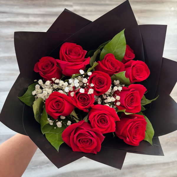 Bouquet of red roses with white baby's breath in black wrap